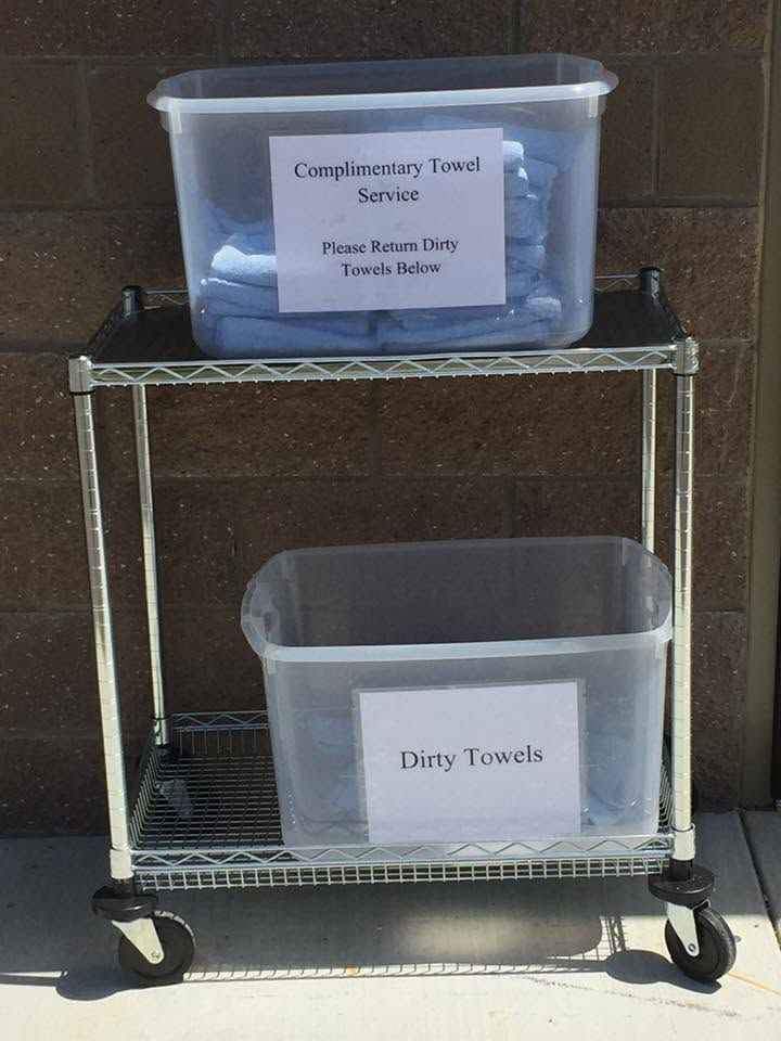 Complimentary towel cart with clean towels on top and a bin for used towels below