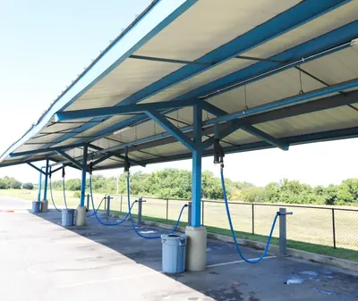 Covered vacuum stations with blue hoses beside the lot